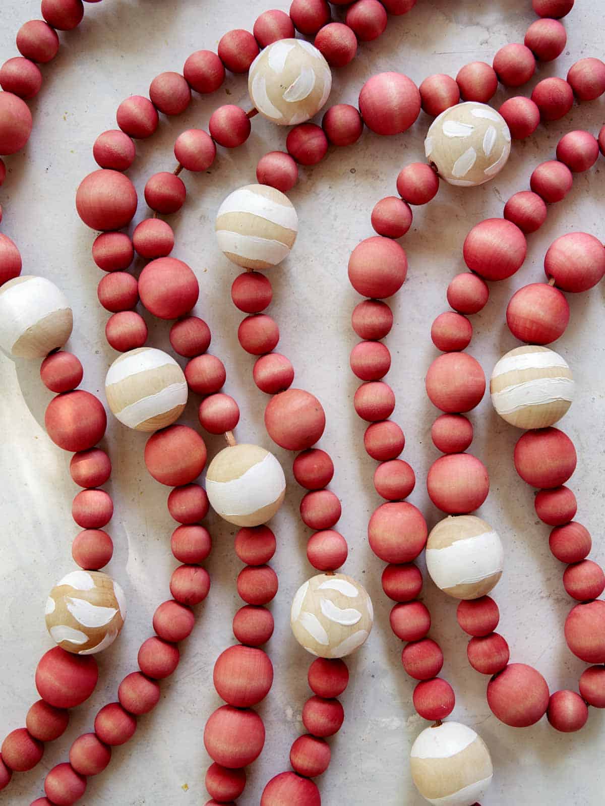 DIY Christmas garland made of wood beans laid out on a surface. 