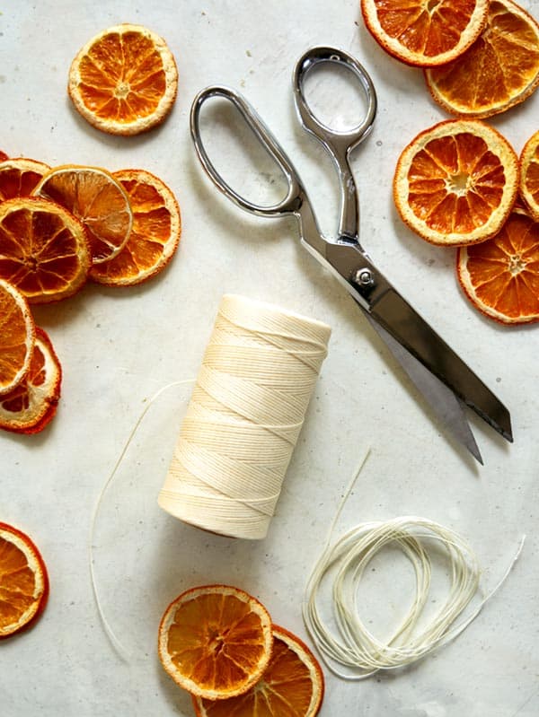 Twine and scissors with dehydrated citrus around it.