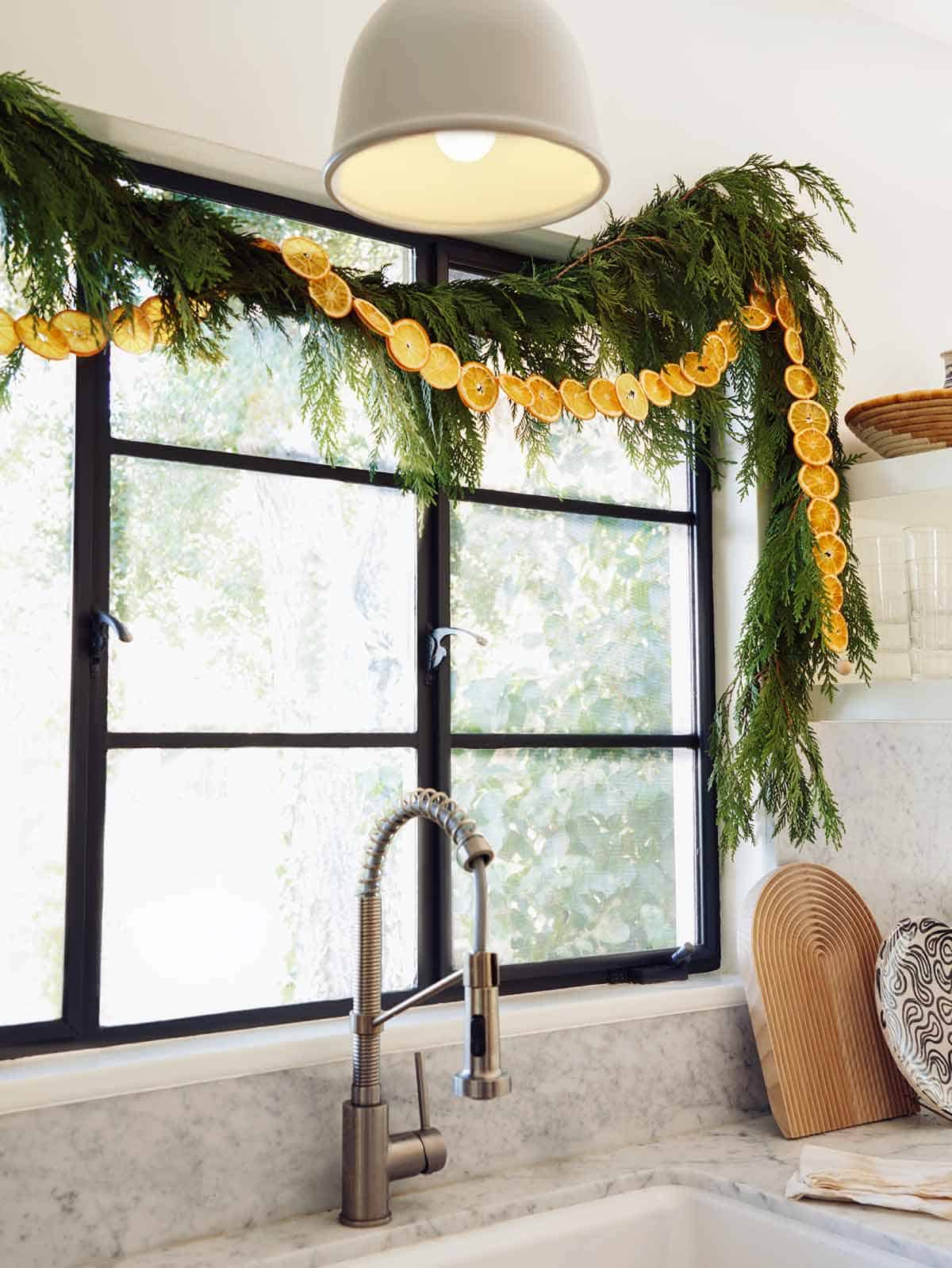 A dehydrated citrus garland strung up above a window in the kitchen.