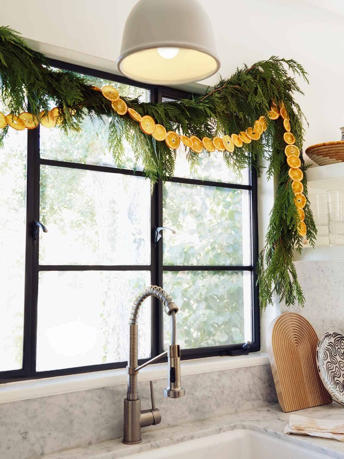 A dehydrated citrus garland strung up above a window in the kitchen. 