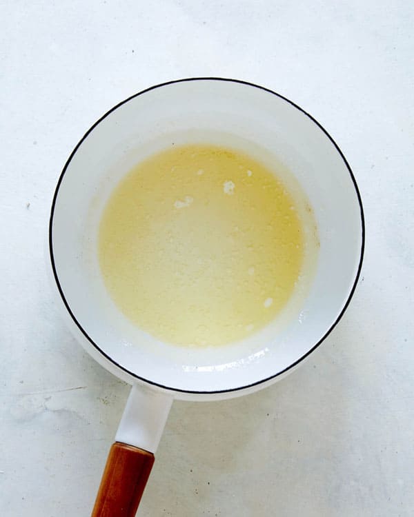 Melted butter in a skillet on a kitchen counter.
