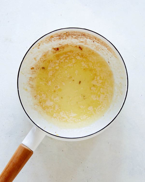 Melted butter in a skillet on a kitchen counter.