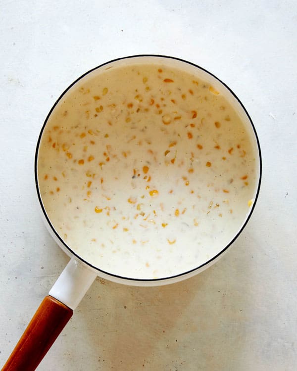 Creamed corn simmering in a skillet.