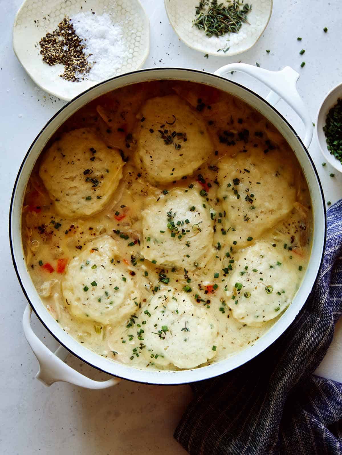 A pot of chicken and dumpling recipe with a napkin next to it.