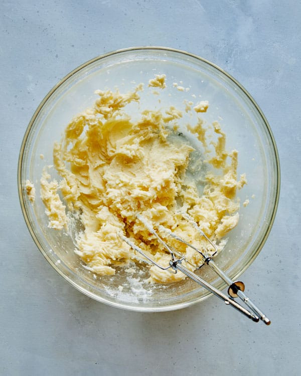 Cream together butter and sugar in a glass bowl.