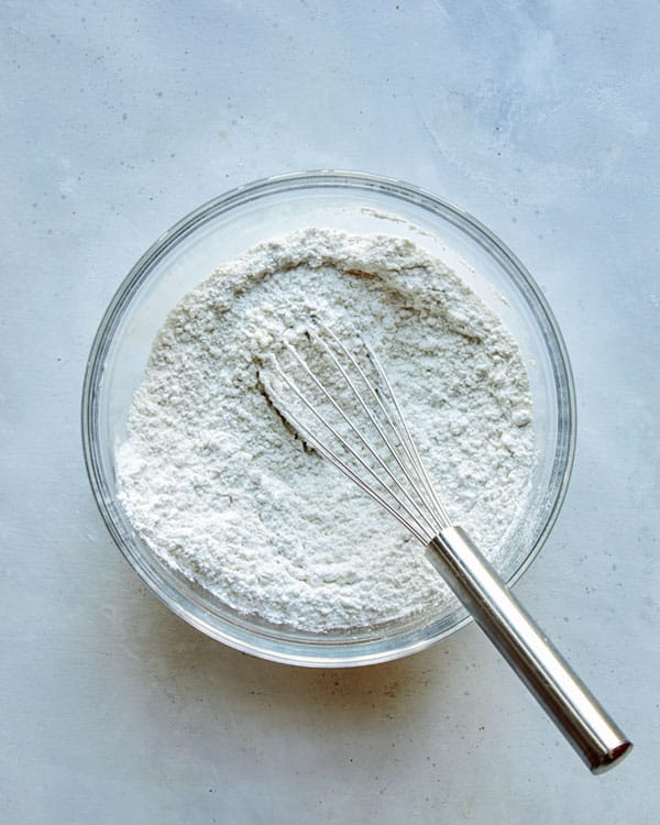 Dry ingredients whisked together in a glass bowl for german apple cake.