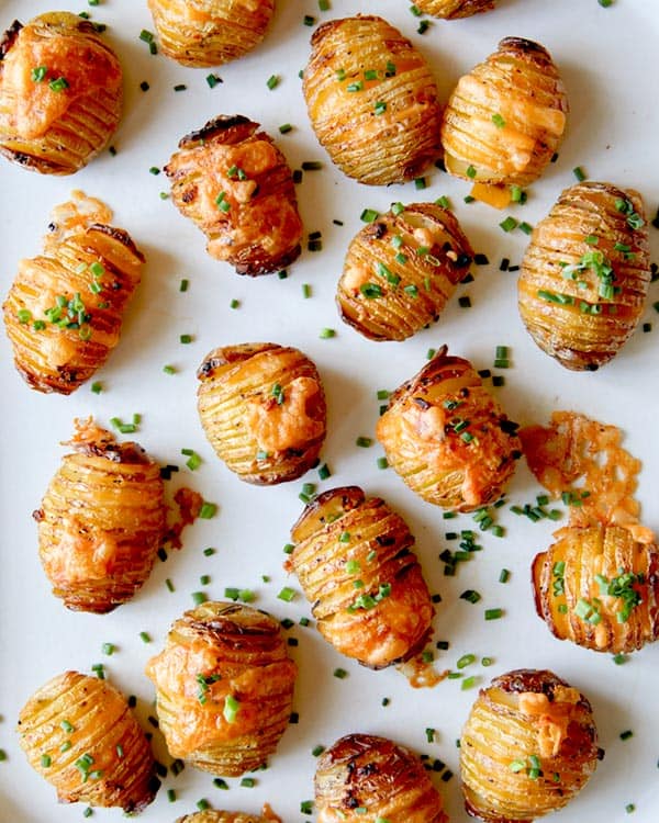 Hasselback potatoes with cheese on top and sprinkled with chives.