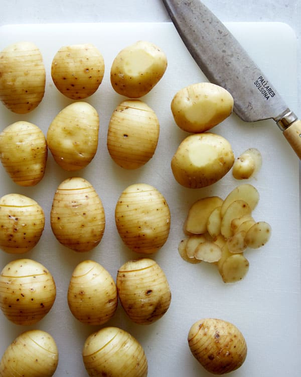 Slicing the bottom of potatoes to make them level.