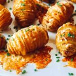 Close up on hasselback potatoes on a platter.