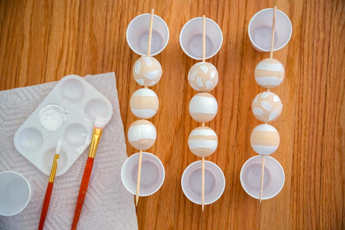 Beads painted then suspended with skewers and cups.
