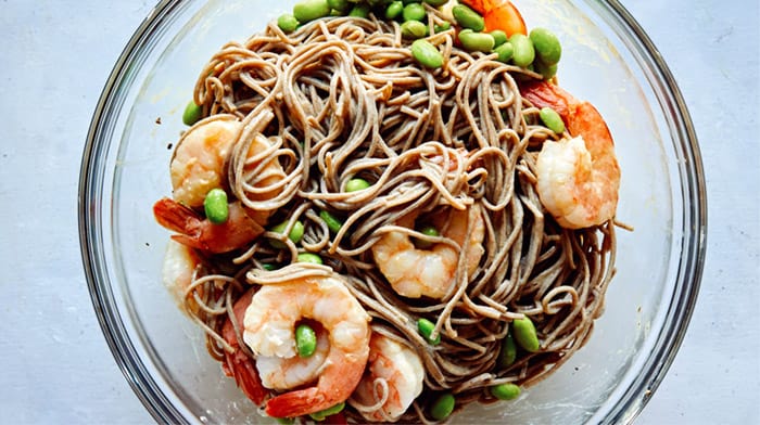 Soba noodles with shrimp in a glass bowl.