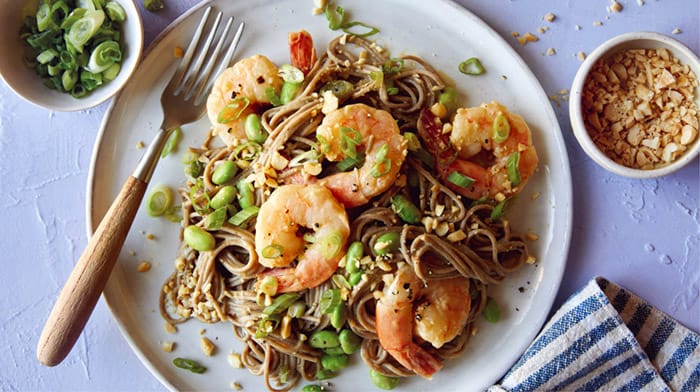 Close up on a soba noodle recipe with shrimp and a fork with it.
