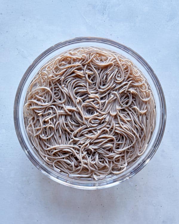 Soba noodles soaking in a bowl with water. 