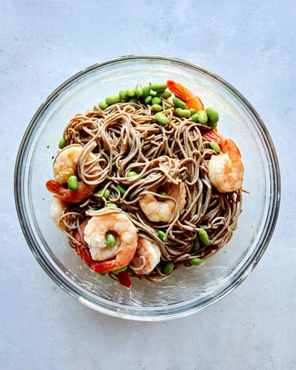 Soba noodles with shrimp in a glass bowl.