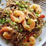 Close up on a soba noodle recipe with shrimp and a fork with it.