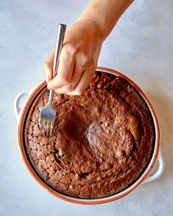 Poking sticky toffee pudding with a fork.