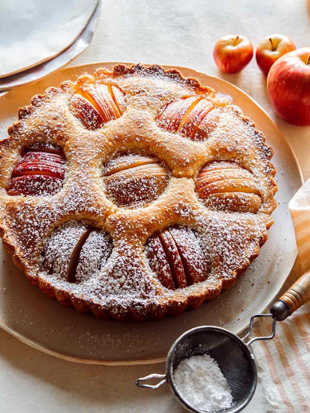 German apple cake on a platter with a stack of plates next to it. 