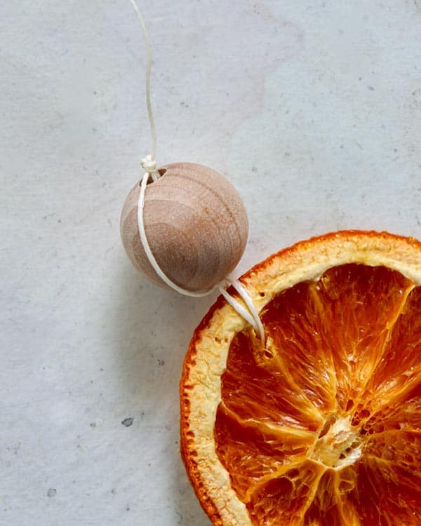A wooden bead strung on the end of citrus garland.  