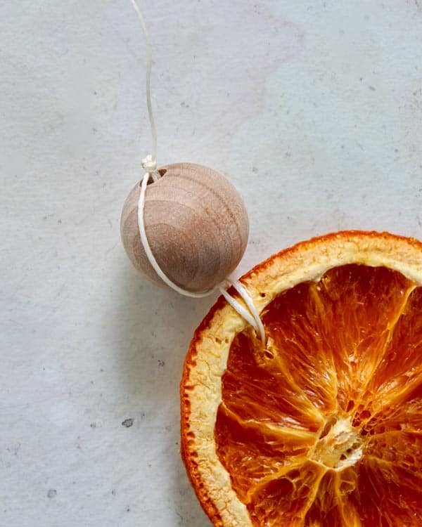 A wooden bead strung on the end of citrus garland.