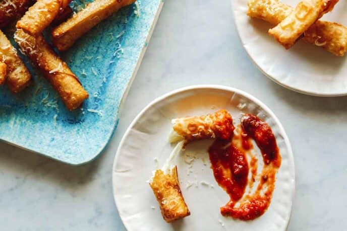 Wonton mozzarella sticks on some plates. 