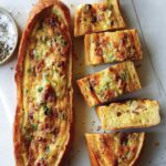 Two baked egg boats on a surface and one cut up.