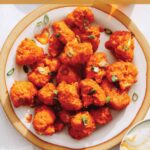 Buffalo cauliflower recipe on a plate with beers next to it.