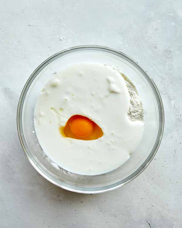 Batter for buffalo cauliflower in a glass bowl ready to be whisked together.