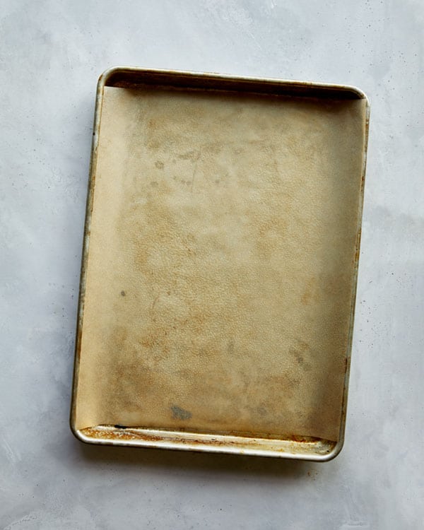 A baking sheet lined with parchment and oiled to make buffalo cauliflower.