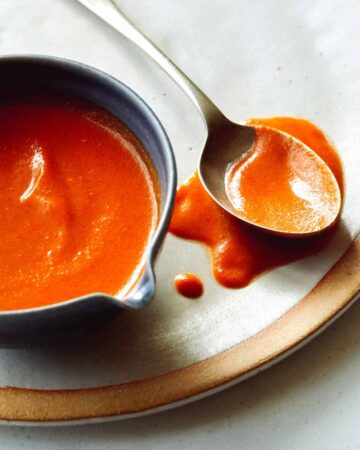 Buffalo sauce recipe in a bowl with a spoon next to it.