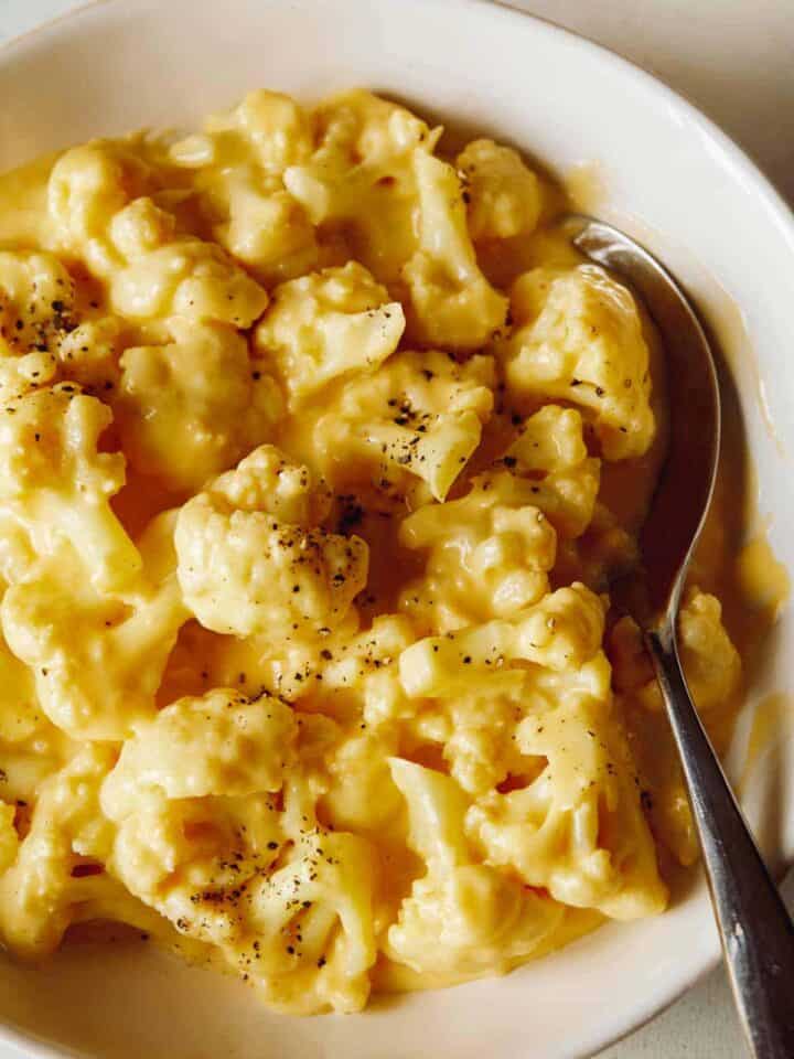 Creamy Cauliflower mac and cheese in a bowl with a spoon.