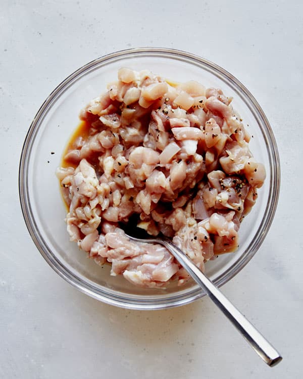 Chicken thighs in a bowl for chicken lettuce wraps recipe.
