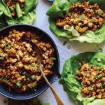 Chicken lettuce wraps with lettuce and chicken in them on the side.