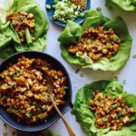 Chicken lettuce wraps with lettuce and chicken in them on the side.