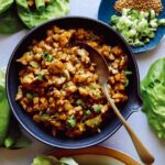 Chicken lettuce wraps recipe in a bowl with lettuce wraps on the side.