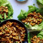 Chicken lettuce wraps with lettuce and chicken in them on the side.