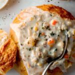 Clam chowder in a bread bowl with a spoon in one.