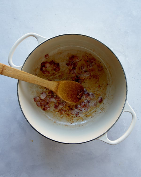 Crisping up bacon in a pot to make clam chowder.