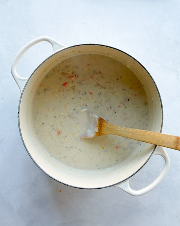 Clam chowder in a pot with milk added to make it creamy.