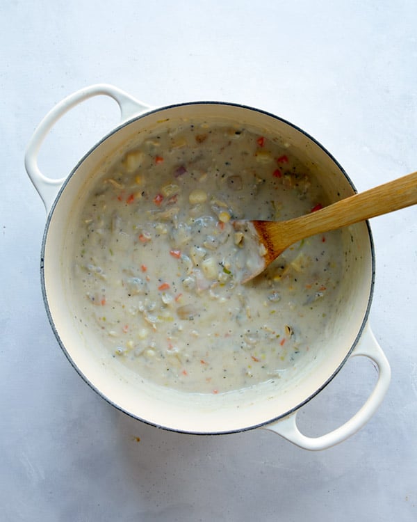 Clam chowder in a pot simmering to make it thick.