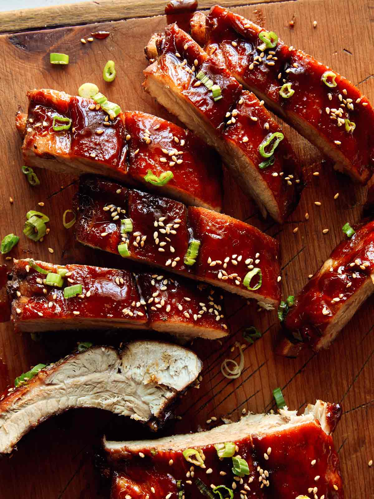 A close up on sticky oven baked ribs on a cutting board. 