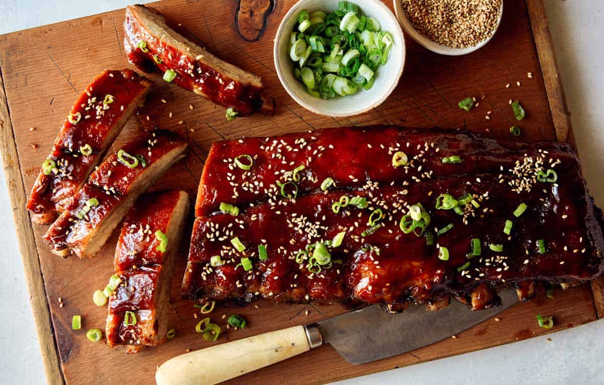 Honey hoisin oven baked ribs on a cutting board.