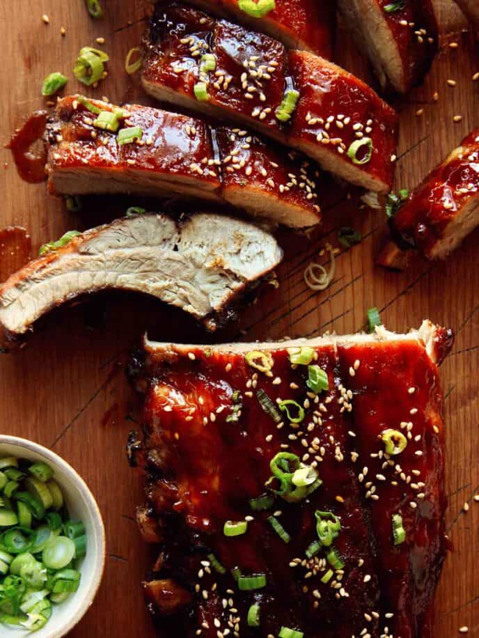 Oven baked sticky ribs on a cutting board.