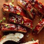 A close up on sticky oven baked ribs on a cutting board.