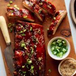 Oven baked sticky ribs on a cutting board.