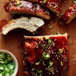 Oven baked ribs being served on a cutting board.