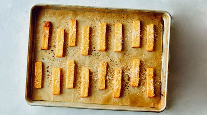 Baked polenta fries sprinkled with parmesan.