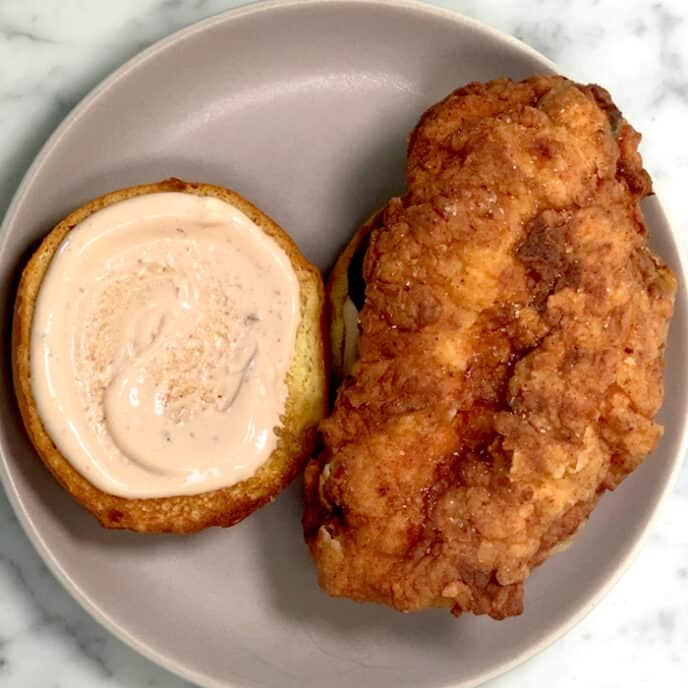 Building a popeyes chicken sandwich on a plate. 