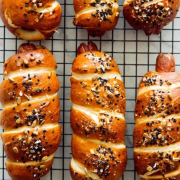 A close up of pretzel dogs on a cooling rack.