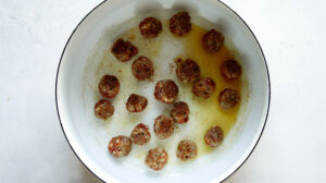 Turkey sausage meatballs seared in a stock pot for tortellini soup.