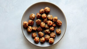 A plate of sausage meatballs on a kitchen counter.